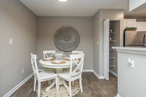 Atlantic Beach apartment for rent - A dining room with a round decorative plate on the wall and a white dining table with four chairs.