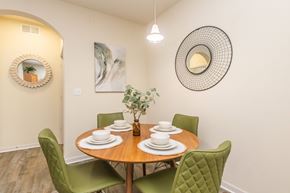 Dade City apartment for rent - A dining room with a round table and green chairs.