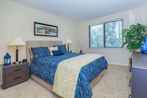 East Hartford apartment for rent - A bedroom with a bed, nightstands, and a plant.