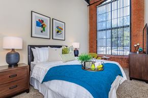 Manchester apartment for rent - A bedroom with a bed, nightstands, and a window.