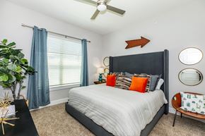 Dallas apartment for rent - A bedroom with a large bed and a ceiling fan.