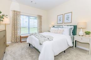Manchester apartment for rent - A bedroom with a large bed and a window with curtains.