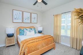 Yulee apartment for rent - A bedroom with a bed, two lamps, and pictures on the wall.