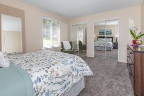 Rocky Hill apartment for rent - A bedroom with a large bed and a mirrored closet door.