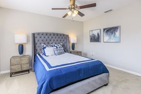 Spring Hill apartment for rent - A bedroom with a large bed and a ceiling fan.