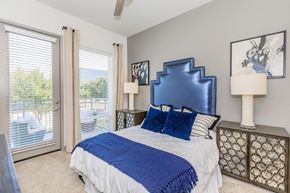 Dallas apartment for rent - A bedroom with a large bed and a blue headboard.
