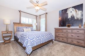 Jacksonville apartment for rent - A bedroom with a bed, dresser, and ceiling fan.