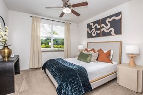 Jacksonville apartment for rent - A bedroom with a bed, nightstands, and a ceiling fan.