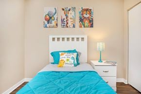 Jacksonville apartment for rent - A bedroom with a white bed and a blue comforter.