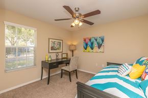 Riverview apartment for rent - A bedroom with a bed, desk, chair, and a ceiling fan.