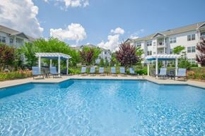 Simsbury apartment for rent - A large swimming pool in front of apartment buildings.