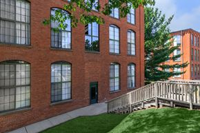 Manchester apartment for rent - A red brick building with a green door and a wooden staircase.