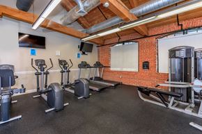 Manchester apartment for rent - A gym with a variety of exercise equipment including treadmills, stationary bikes, and weight machines.