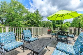 Simsbury apartment for rent - A yellow umbrella sits on a patio table surrounded by chairs.