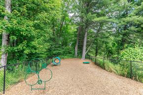 Simsbury apartment for rent - A playground with a slide and swings in a wooded area.