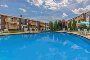 Naugatuck apartment for rent - A large blue swimming pool in front of apartment buildings.
