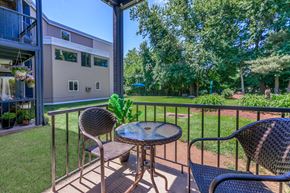 East Haven apartment for rent - A patio with a table and chairs overlooking a green lawn.
