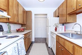 Groton apartment for rent - A kitchen with wooden cabinets and white appliances.