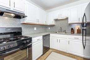 West Haven apartment for rent - A modern kitchen with white cabinets and a black stove top.