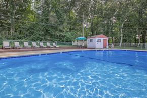 Rocky Hill apartment for rent - A pool with a red building and sun loungers in the background.