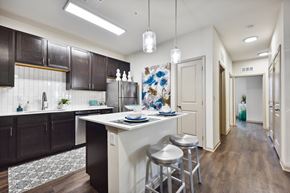 Jacksonville apartment for rent - A kitchen with dark brown cabinets and a white island.