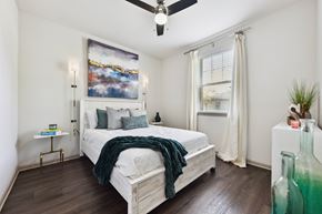 Jacksonville apartment for rent - A bedroom with a large bed and a painting on the wall.