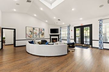 Dade City apartment for rent - A living room with a white circular couch and a fireplace.