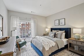 Stamford apartment for rent - A bedroom with a large bed and a chair by the window.