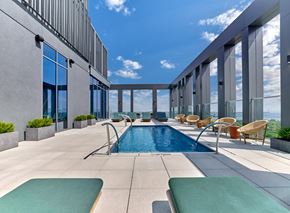 Jersey City apartment for rent - a swimming pool on the rooftop of a building with a blue sky
