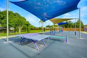 Orlando apartment for rent - A playground with a purple table and a blue shade structure.