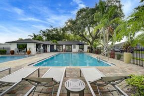 Orlando apartment for rent - A pool surrounded by a patio with chairs and a table.