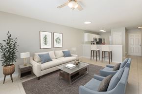 Lady Lake apartment for rent - A living room with a grey couch, a coffee table, and a ceiling fan.
