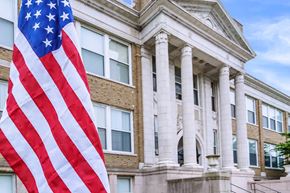 West Haven apartment for rent - An American flag hangs in front of a building with columns.