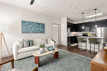 Bloomfield apartment for rent - A modern living room with a white couch and a painting on the wall.