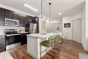 Bloomfield apartment for rent - A modern kitchen with dark brown cabinets and a white island.