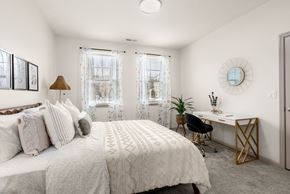 Bloomfield apartment for rent - A bedroom with a large bed and a desk with a chair.
