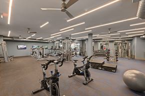 Dallas apartment for rent - A gym with a variety of exercise equipment including treadmills, stationary bikes, and weight machines.