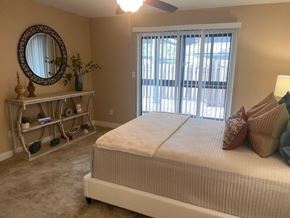 Bradenton apartment for rent - A bedroom with a bed, a dresser, and a mirror.