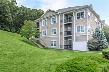 Manchester apartment for rent - A large apartment building with a green lawn in front.