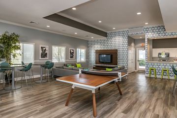 Jacksonville apartment for rent - A modern living room with a wooden table and green chairs.