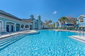 Jacksonville apartment for rent - A large swimming pool in front of a building with a clock tower.