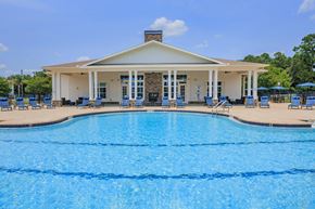 Yulee apartment for rent - A large swimming pool in front of a building with a white roof.