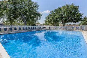 Spring Hill apartment for rent - A large outdoor swimming pool surrounded by a fence.