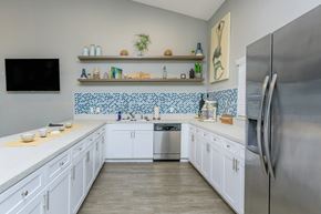 Spring Hill apartment for rent - A kitchen with white cabinets and a blue tile backsplash.