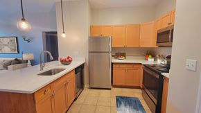 Meriden apartment for rent - A kitchen with wooden cabinets and a refrigerator.