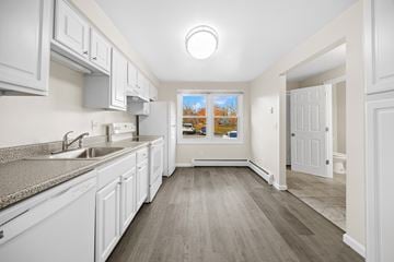 Meriden townhouse for rent - A kitchen with white cabinets and a grey counter top.