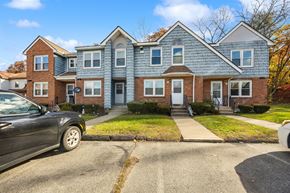 Meriden townhouse for rent - A two-story house with a grey roof and a black car parked in front.