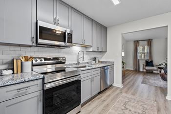A modern kitchen with a black oven and grey cabinets
