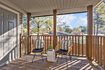 Two chairs on a porch with a pillow on the back of each chair
