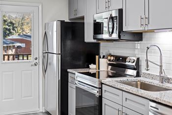 A kitchen with a black fridge and stove